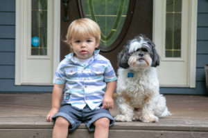little boy and dog on porch